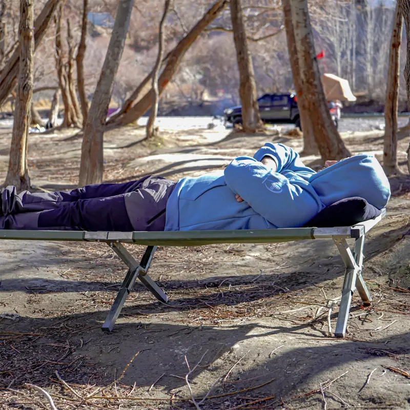 نمای نزدیک از فرد دراز کشیده شده روی تخت خواب سفری