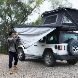 فردی در حال باز کردن سایبان بغل (Wild Land) از نمای کنار